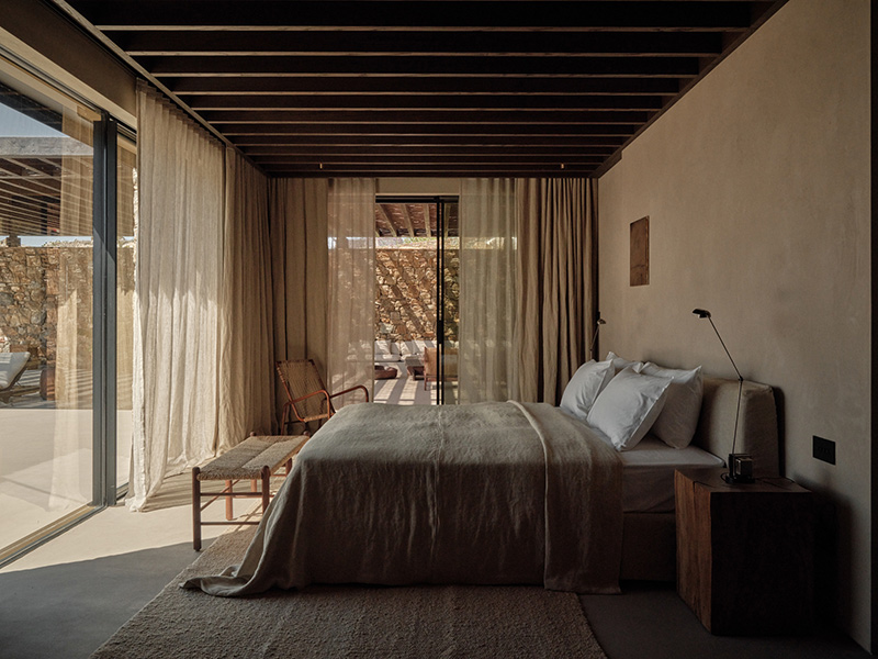 Une chambre du premier niveau, ouvrant sur la terrasse principale dans un style minimaliste bohème Une chambre du premier niveau, ouvrant sur la terrasse principale dans un style minimaliste bohème