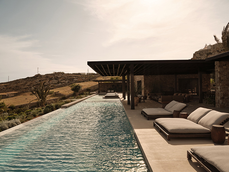 La piscine de la villa En Kyanó, donnant sur la mer Méditerranée La piscine de la villa En Kyanó, donnant sur la mer Méditerranée avec ses installations de mobilier design minimaliste dans les tonalités wabi sabi