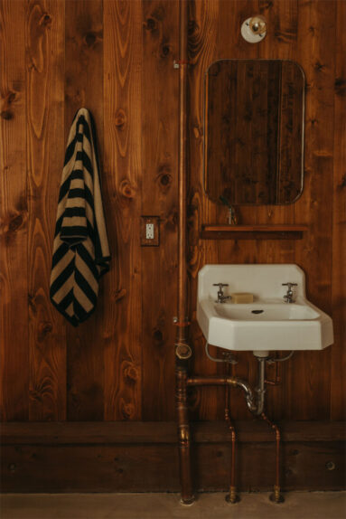 La cabane Coveside Carriage House - Lavabo vintage sur mur couvert de lambris teinté
