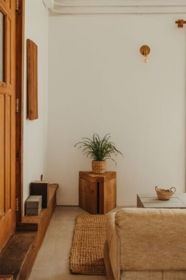 La cabane Coveside Carriage House - L'espace minimaliste avec des éléments en bois et tapis coco sur sol en béton ciré