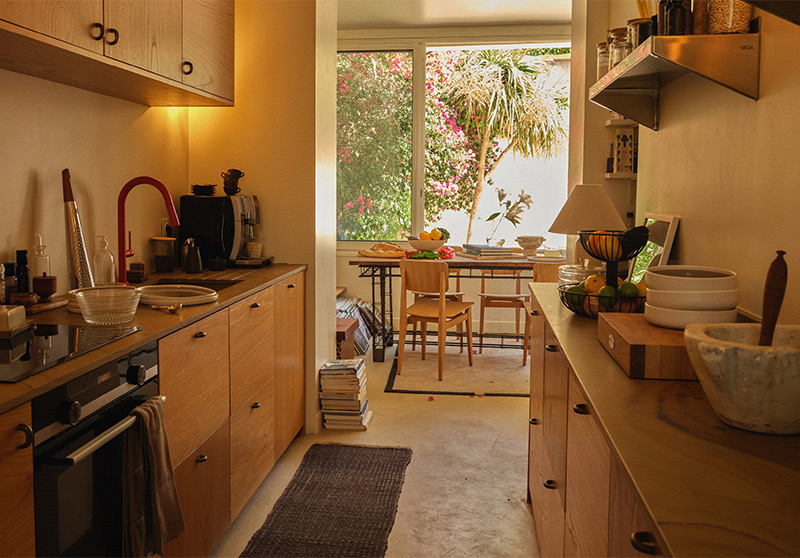 Le refuge d'Erin Wasson à Marseille : la cuisine en mode couloir avec des placards plaqués noyer et plan de travail en marbre