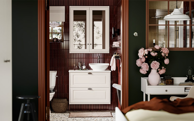 Salle de bains parentale avec de la faïence bordeaux sur laquelle se détache les meubles blancs IKEA de la gamme Tännforsen Salle de bains parentale avec de la faïence bordeaux sur laquelle se détache les meubles blancs IKEA de la gamme Tännforsen