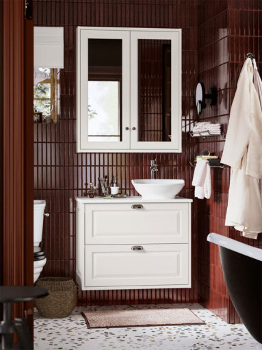 Salle de bains parentale avec de la faïence bordeaux sur laquelle se détache les meubles blancs IKEA de la gamme Tännforsen Salle de bains parentale avec de la faïence bordeaux sur laquelle se détache les meubles blancs IKEA de la gamme Tännforsen