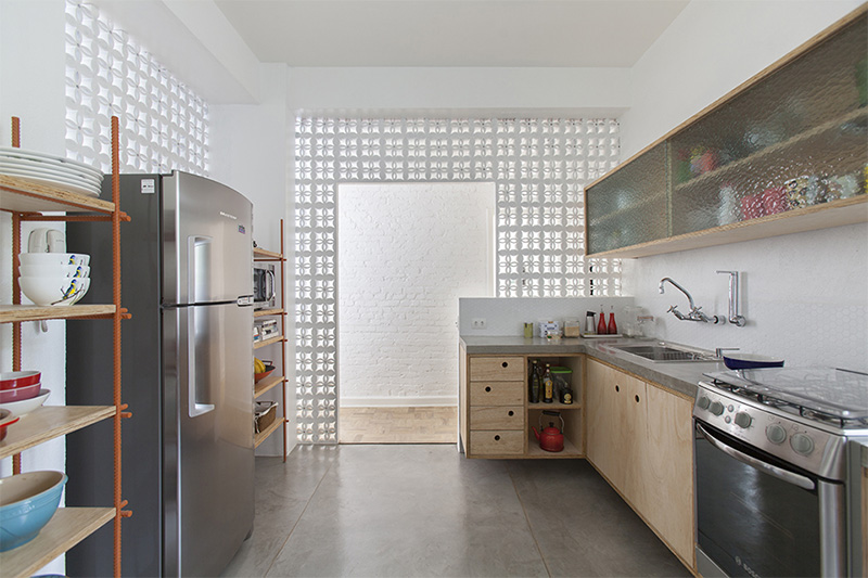 Une cuisine séparée du reste de l'appartement en claustra blanc