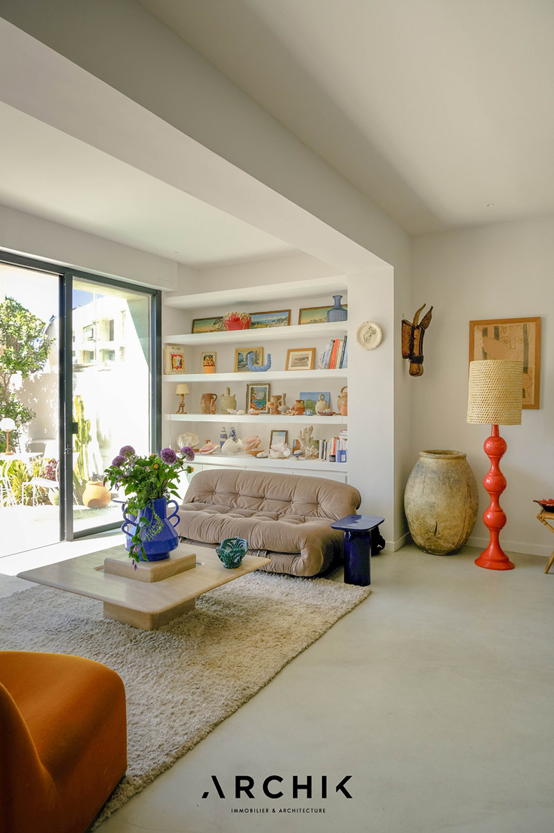 Un salon de style moderne, monochrome blanc sur lequel se détâchent du mobilier design et des objets colorés Un salon de style moderne, monochrome blanc sur lequel se détâchent du mobilier design et des objets colorés