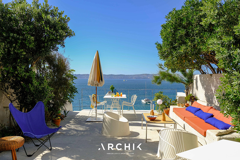 La grande terrasse avec une vue plongeante sur la Méditerranée et son mobilier de jardin coloré La grande terrasse avec une vue plongeante sur la Méditerranée et son mobilier de jardin coloré