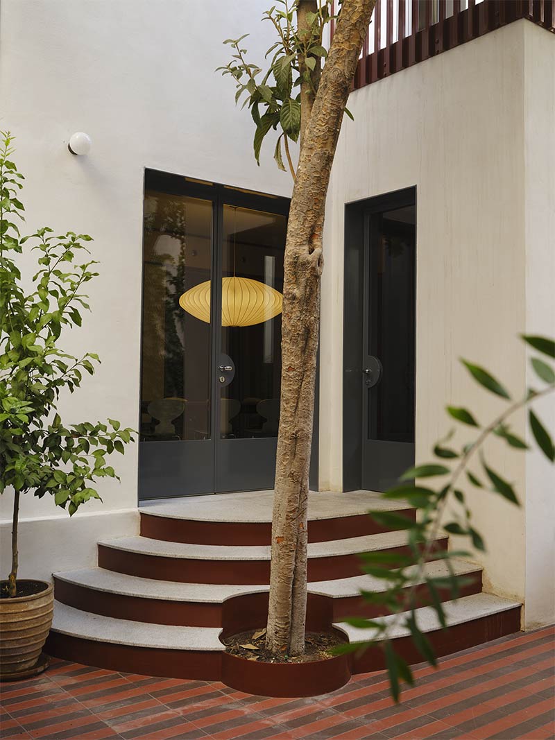 L'entrée de la maison avec un arbre intégré à l'escalier L'entrée de la maison avec un arbre intégré à l'escalier