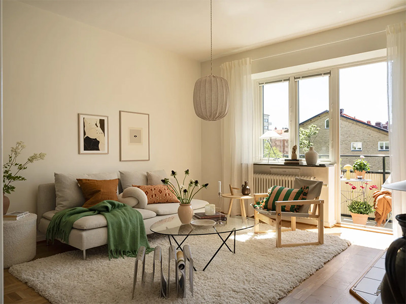 Salon de style scandinave lumineux dans un camaïeu de beige et crème, rehaussé par quelques accessoires déco colorés.