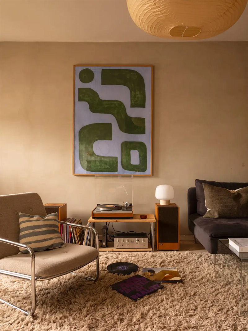 Salon scandinave beige au style vintage moderne avec son tapis Shaggy et son mobilier esprit seventies