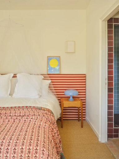 Une des chambres avec la tête de lit à rayures horizontale en rouge et rose Une des chambres avec la tête de lit à rayures horizontale en rouge et rose