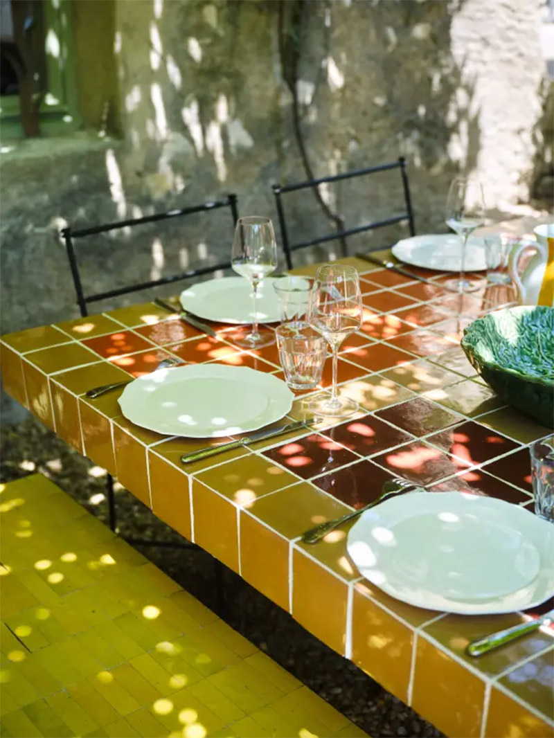 La table extérieure couverte de carreaux de faïence de différentes couleurs La table extérieure couverte de carreaux de faïence de différentes couleurs