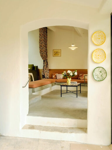 Le salon avec sa banquette maçonnée et ses coussins terracotta Le salon avec sa banquette maçonnée et ses coussins terracotta