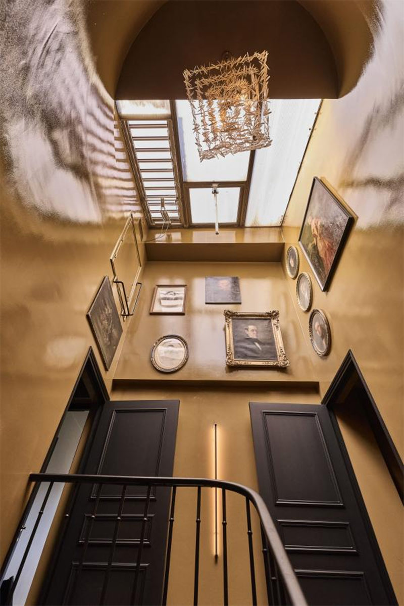 La cage d'escalier peinte dans une laque jaune ocre avec en déco des portraits anciens de famille La cage d'escalier peinte dans une laque jaune ocre avec en déco des portraits anciens de famille
