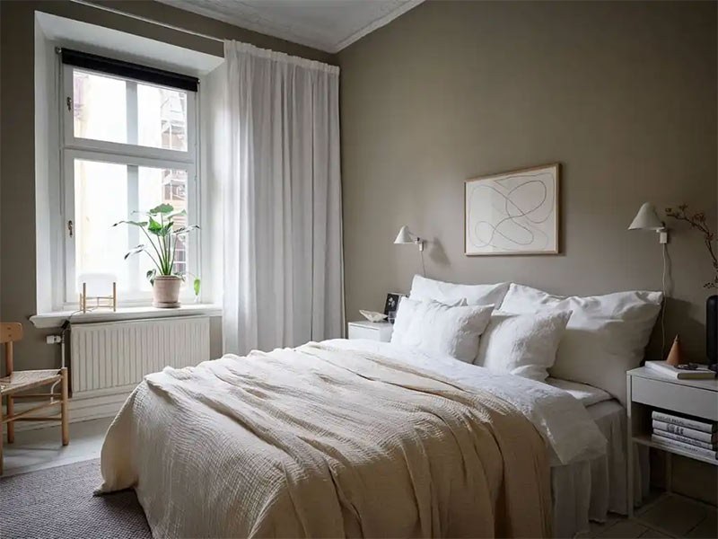 Chambre au mur taupe avec linge de lit en lin et tapis grège en laine Chambre au mur taupe avec linge de lit en lin et tapis grège en laine