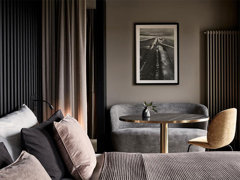 Chambre au mur taupe avec tête de lit en lin et tapis grège en laine Chambre d'hôtel standing à la palette de couleurs taupe